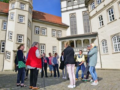 Eine Gästeführerin mit einer Gruppe im Gifhorner Schlosshof.