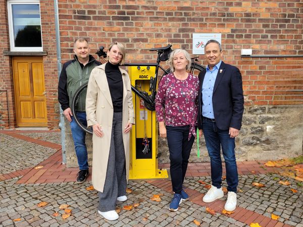 Eröffnung der Radservice-Station, Beteiligte vor der gelben Reparaturstation für Fahrräder Hessisch Oldendorf