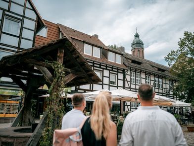 Eine Familie steht neben dem Brunnen auf dem Hallenplan.
