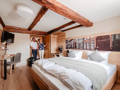 Einbecker Hof 2 Menschen in einem Hotelzimmer im Fachwerkstil.