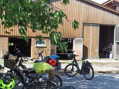 Fahrräder stehen vor einem Kuhstall.