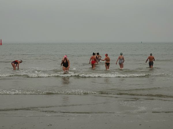 Leichtbekleidete Badegäste in der Nordsee im Winter