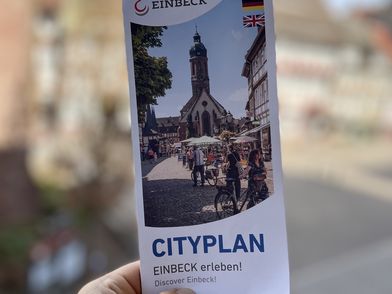 Zusammengefalteter Stadtplan, der von einer Hand gehalten wird.